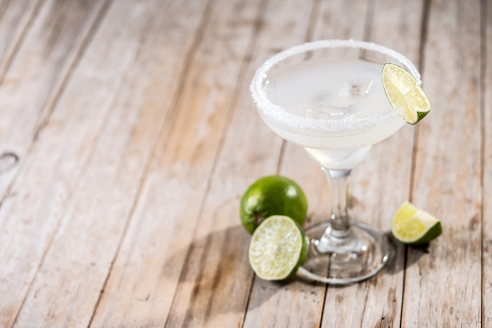 Margarita de limón verde servida sobre mesa de madera