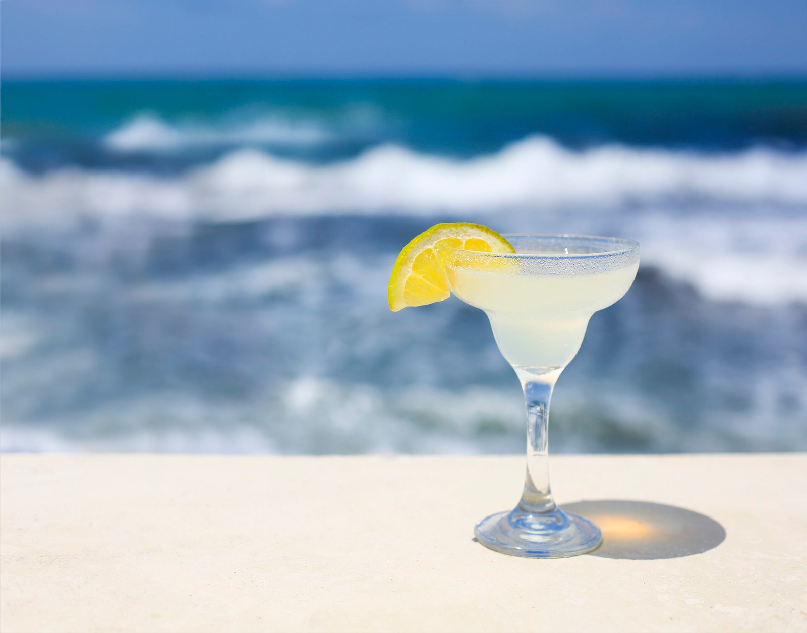 Cóctel Margarita frente a una playa tropical
